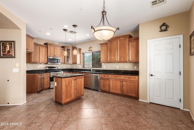 kitchen featuring appliances with stainless steel finishes, brown cabinetry, and dark countertops