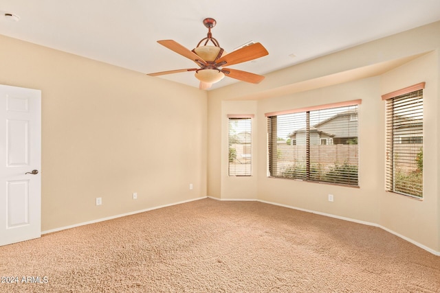 empty room featuring carpet floors, a ceiling fan, and baseboards