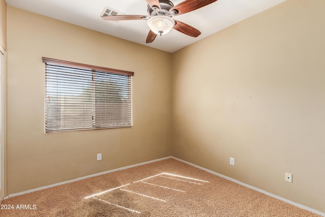 carpeted empty room with ceiling fan and baseboards