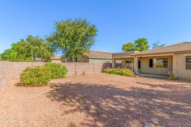 view of yard with a ceiling fan, a fenced backyard, and a patio