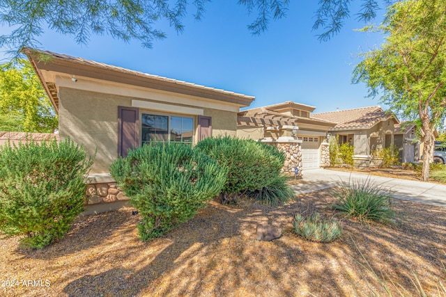 view of front of home featuring an attached garage, a tile roof, concrete driveway, stone siding, and stucco siding