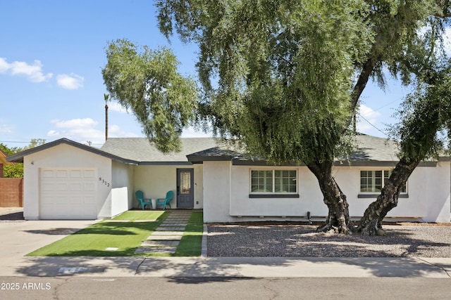 ranch-style home featuring a shingled roof, an attached garage, and stucco siding