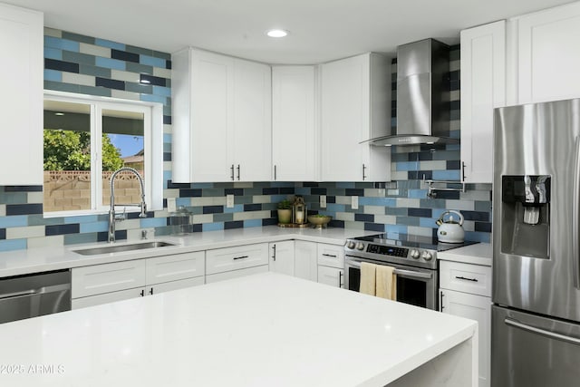 kitchen with appliances with stainless steel finishes, a sink, wall chimney range hood, and decorative backsplash