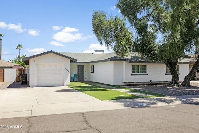 ranch-style home featuring a garage, concrete driveway, a shingled roof, and stucco siding