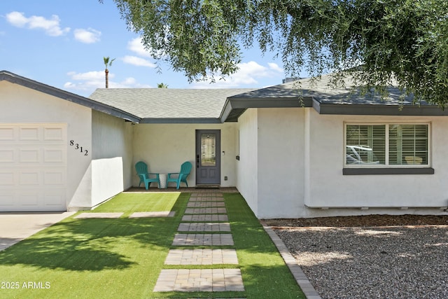 view of front facade featuring roof with shingles, an attached garage, and stucco siding