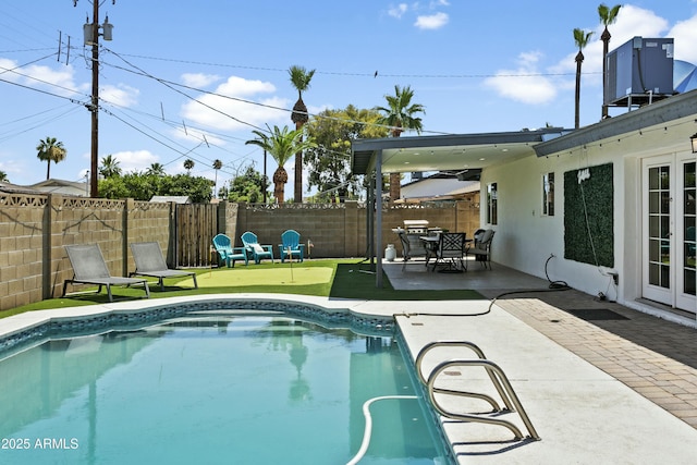 view of pool with a patio, central AC, and a fenced backyard