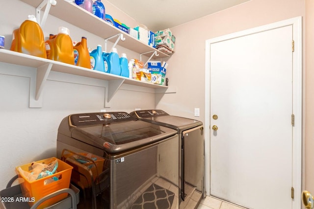 clothes washing area featuring washer and dryer and light tile patterned floors