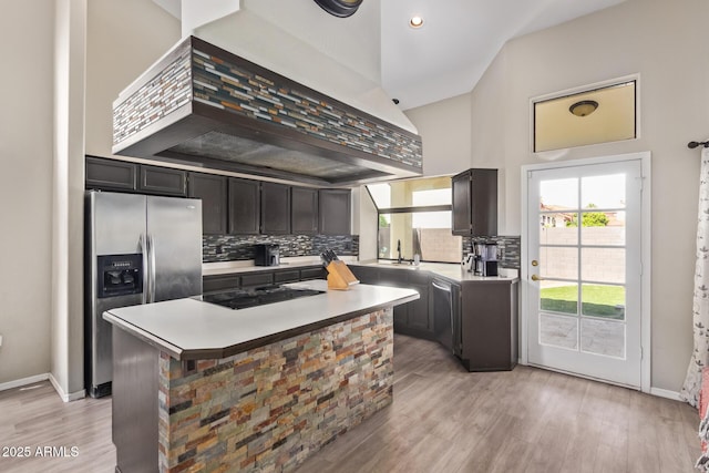 5428 W Wethersfield Dr, Glendale, AZ 85304 - kitchen with black electric cooktop, light countertops, stainless steel fridge, custom exhaust hood, and tasteful backsplash