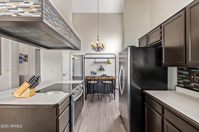 5428 W Wethersfield Dr, Glendale, AZ 85304 - kitchen with a chandelier, light wood finished floors, tasteful backsplash, custom exhaust hood, and stainless steel appliances