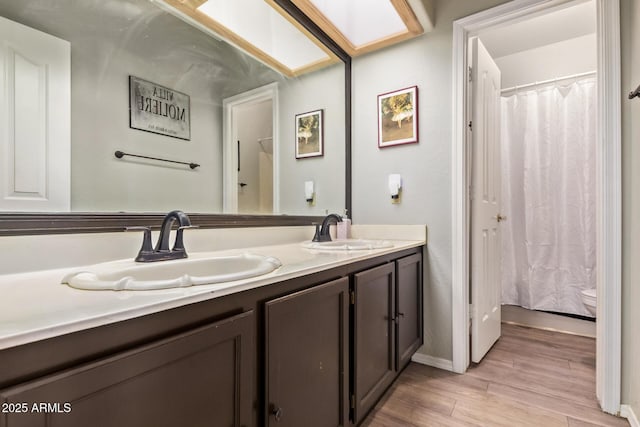 5428 W Wethersfield Dr, Glendale, AZ 85304 - bathroom with double vanity, a sink, toilet, and wood finished floors