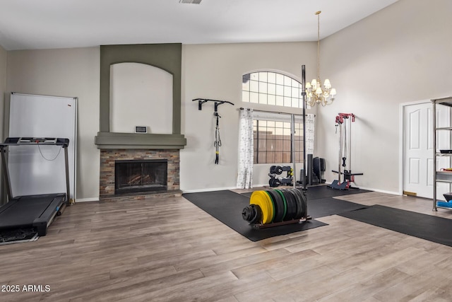 5428 W Wethersfield Dr, Glendale, AZ 85304 - exercise room featuring a towering ceiling, a stone fireplace, baseboards, and wood finished floors