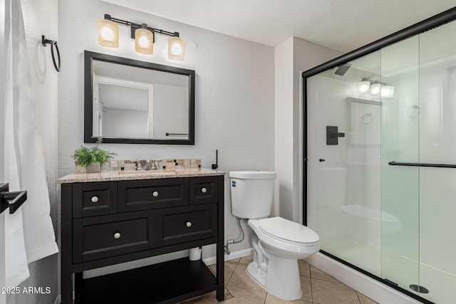 bathroom featuring tile patterned flooring, vanity, a shower with door, and toilet