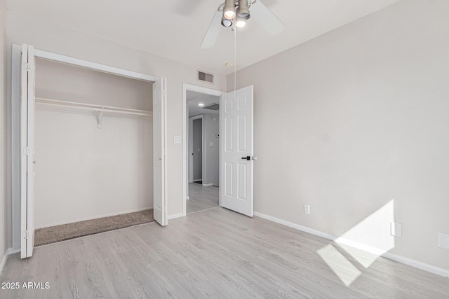 unfurnished bedroom featuring ceiling fan, light wood-type flooring, and a closet