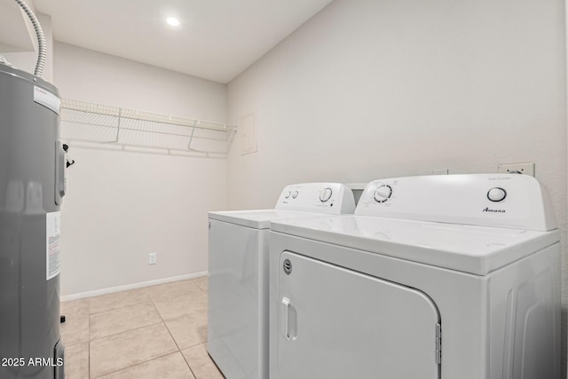 clothes washing area featuring light tile patterned floors, water heater, and washing machine and clothes dryer