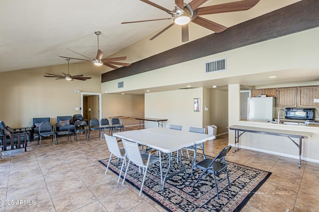 tiled dining room featuring high vaulted ceiling