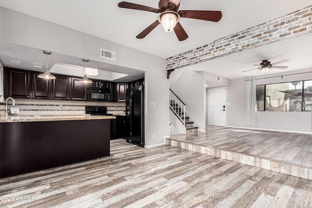 kitchen featuring pendant lighting, decorative backsplash, black appliances, dark brown cabinets, and light hardwood / wood-style flooring