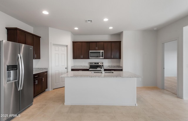 kitchen with stainless steel appliances, visible vents, a sink, and dark brown cabinetry