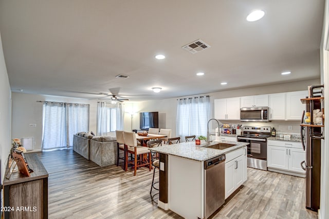 kitchen featuring sink, white cabinets, light hardwood / wood-style floors, and appliances with stainless steel finishes