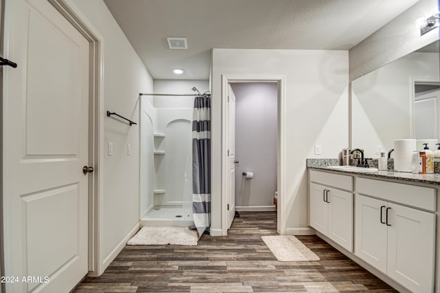 bathroom featuring toilet, wood-type flooring, vanity, and a shower with curtain