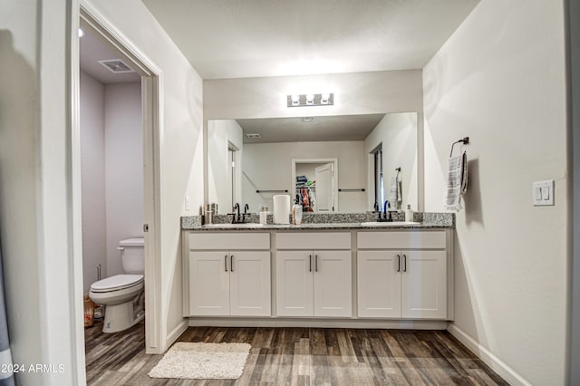 bathroom featuring vanity, hardwood / wood-style flooring, and toilet