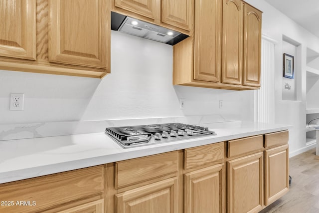 kitchen with light brown cabinetry, stainless steel gas cooktop, custom exhaust hood, and light wood-type flooring