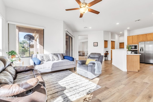 living room featuring light hardwood / wood-style flooring and ceiling fan