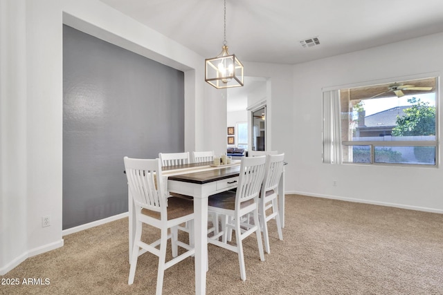 dining space featuring light carpet and a notable chandelier