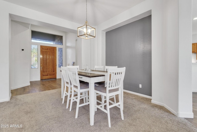 carpeted dining room with an inviting chandelier