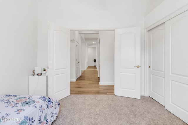 unfurnished bedroom featuring light colored carpet and a closet