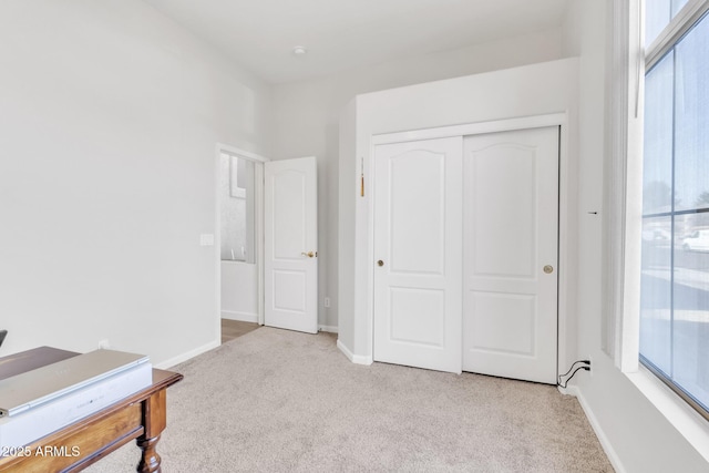 carpeted bedroom featuring a closet and multiple windows