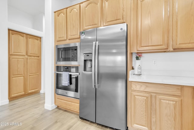 kitchen featuring light brown cabinetry, light hardwood / wood-style flooring, and stainless steel appliances