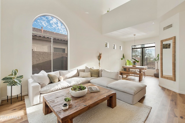 living room featuring a high ceiling and light hardwood / wood-style floors