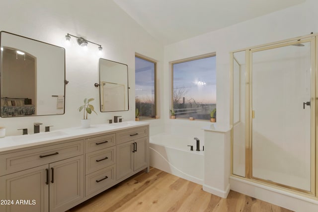 bathroom with independent shower and bath, vanity, wood-type flooring, and vaulted ceiling