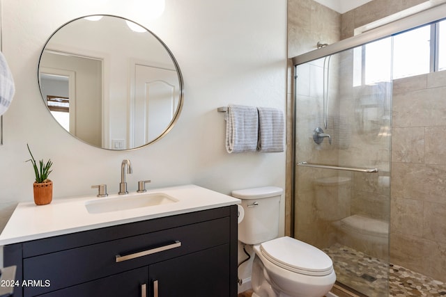 bathroom with walk in shower, vanity, and toilet