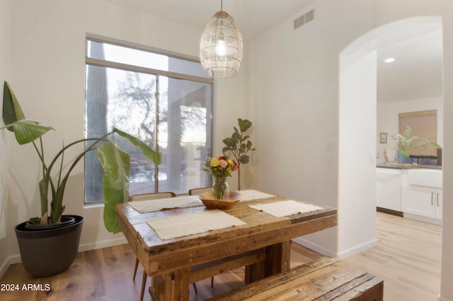 dining space featuring light hardwood / wood-style floors and an inviting chandelier