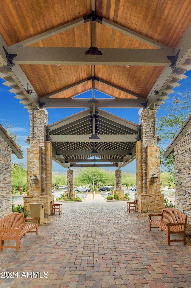 view of patio featuring a gazebo, an outdoor kitchen, and an outdoor stone fireplace