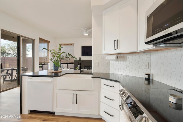 kitchen with dishwasher, light hardwood / wood-style floors, white cabinets, and sink