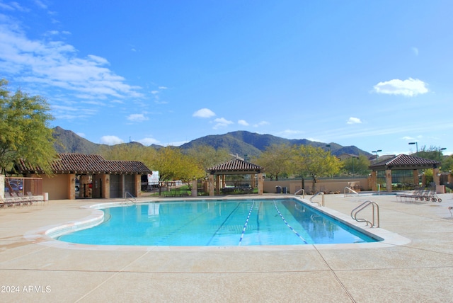 view of swimming pool featuring a patio area, a mountain view, and a gazebo