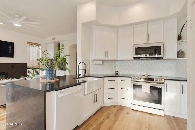 kitchen featuring light hardwood / wood-style floors, white cabinetry, decorative backsplash, and appliances with stainless steel finishes