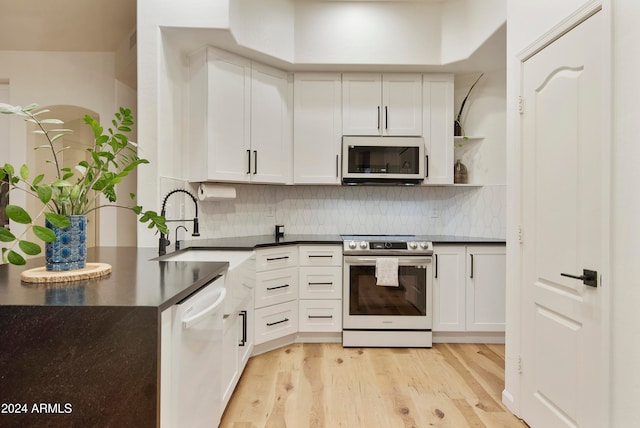 kitchen featuring white cabinetry, appliances with stainless steel finishes, decorative backsplash, and light hardwood / wood-style floors