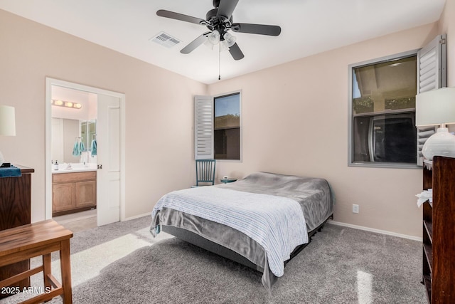 bedroom featuring ceiling fan, light carpet, and ensuite bath