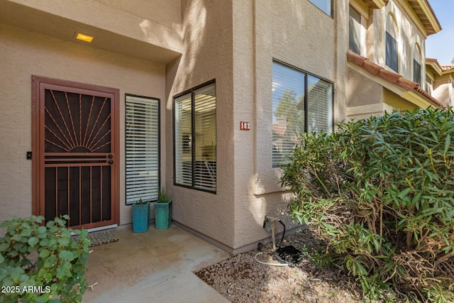 property entrance featuring stucco siding and a tile roof