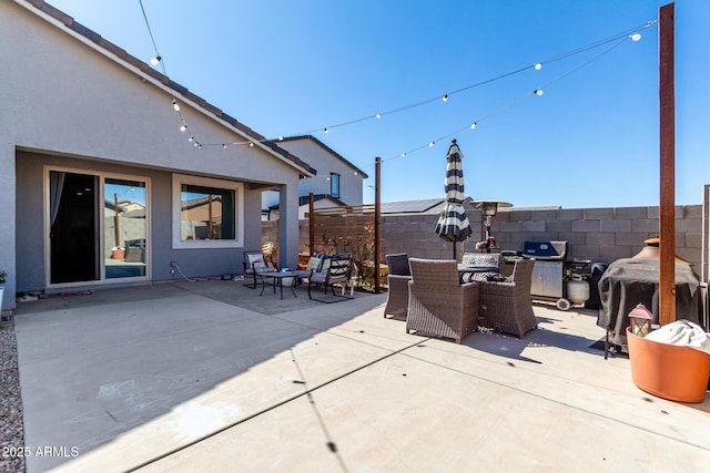 view of patio featuring outdoor dining area, fence, and a grill