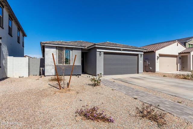 view of front of property featuring a garage, a tile roof, concrete driveway, and stucco siding