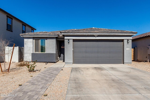 ranch-style house with a garage, driveway, a tile roof, and stucco siding