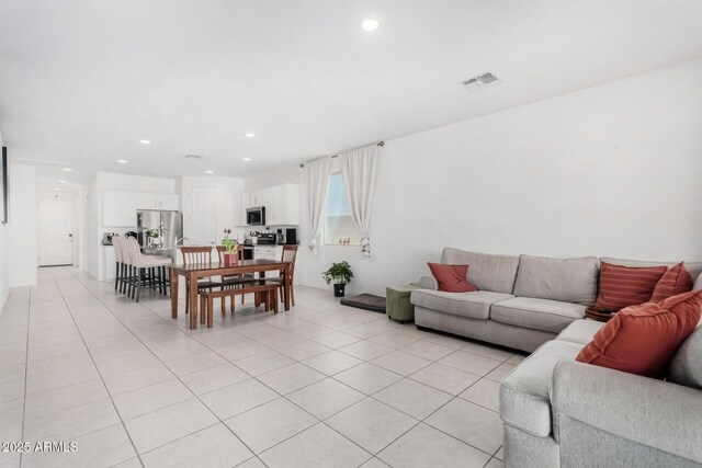 living room with light tile patterned floors, visible vents, and recessed lighting