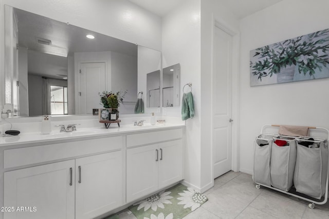 full bathroom with a closet, double vanity, a sink, and tile patterned floors