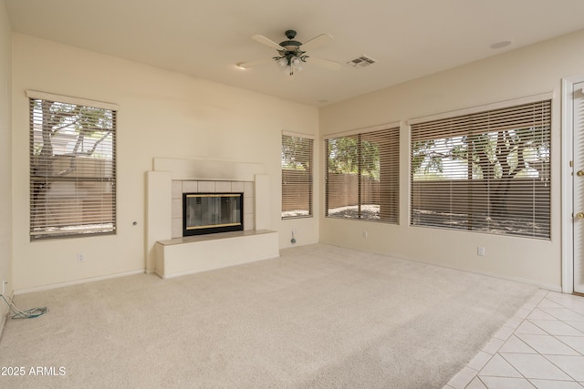 6917 E Night Glow Cir, Scottsdale, AZ 85266 - unfurnished living room with carpet flooring, ceiling fan, a tiled fireplace, and baseboards