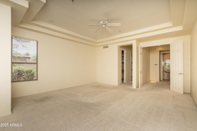 6917 E Night Glow Cir, Scottsdale, AZ 85266 - empty room featuring a raised ceiling, light colored carpet, and a ceiling fan