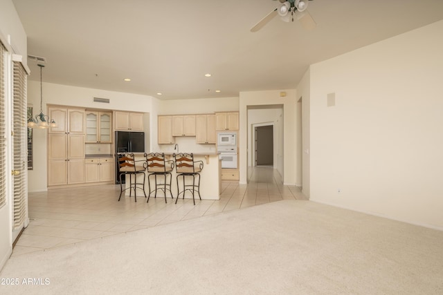 6917 E Night Glow Cir, Scottsdale, AZ 85266 - kitchen featuring white appliances, light brown cabinets, a kitchen bar, recessed lighting, and light colored carpet
